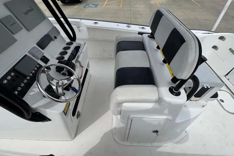 Slide: The Image of 2018 Cape Horn 27 boat cockpit with steering wheel, Garmin electronics, and cushioned seating. - 16