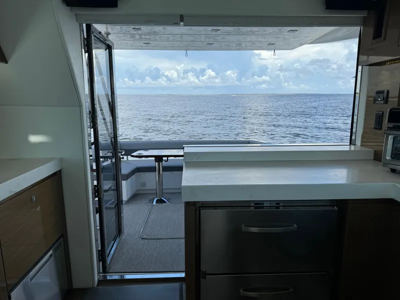 Slide: The Image of 2021 Cruisers Yachts 60 Cantius Flybridge interior with ocean view through open doors. - 39