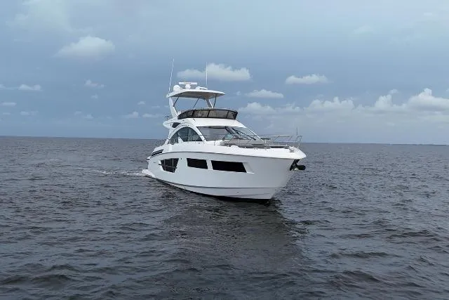 Slide: The Image of 2021 Cruisers Yachts 60 Cantius sailing on open water under cloudy skies. - 76