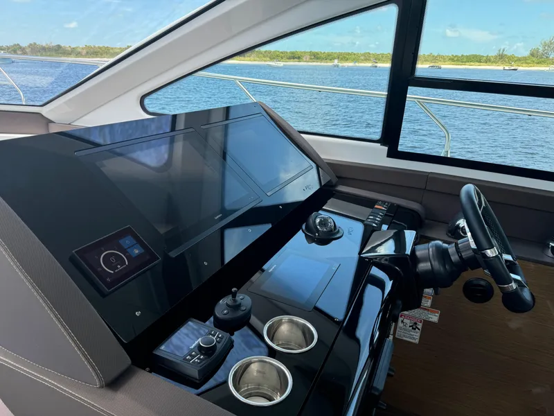 Slide: The Image of Helm of 2021 Cruisers Yachts 60 Cantius Flybridge with modern controls and scenic view. - 23