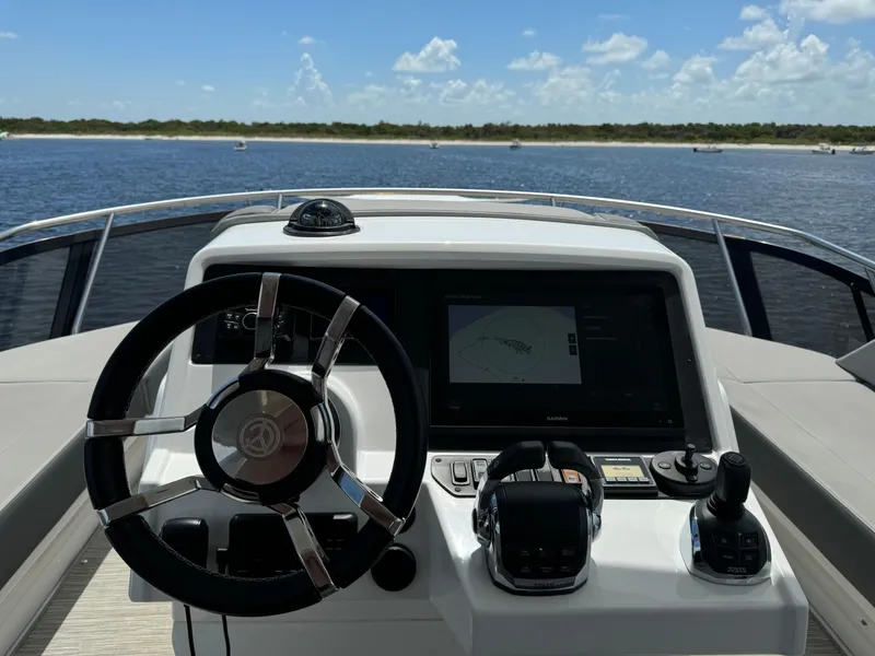 Slide: The Image of 2021 Cruisers Yachts 60 Cantius Flybridge helm with steering wheel and navigation display. - 50