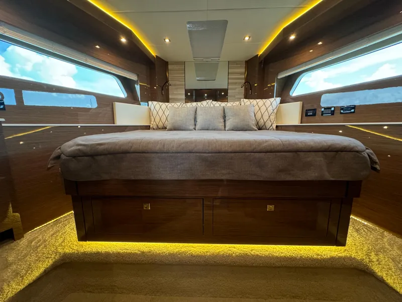 Slide: The Image of Luxurious interior of 2021 Cruisers Yachts 60 Cantius Flybridge with elegant bedding and ambient lighting. - 10