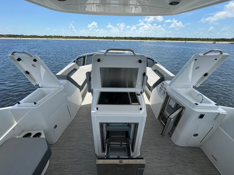 Slide: The Image of 2021 Cruisers Yachts 60 Cantius Flybridge deck with open storage and grill, overlooking water. - 48