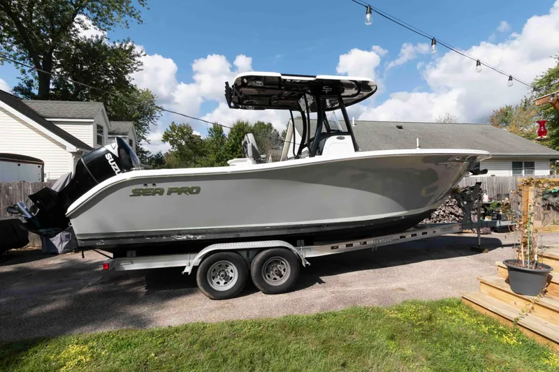 The Image of 2020 Sea Pro 259 Center Console boat on trailer in residential driveway. - 0