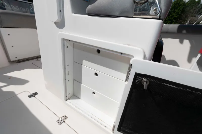 Slide: The Image of 2020 Sea Pro 259 Center Console storage compartment with open door and drawers. - 16