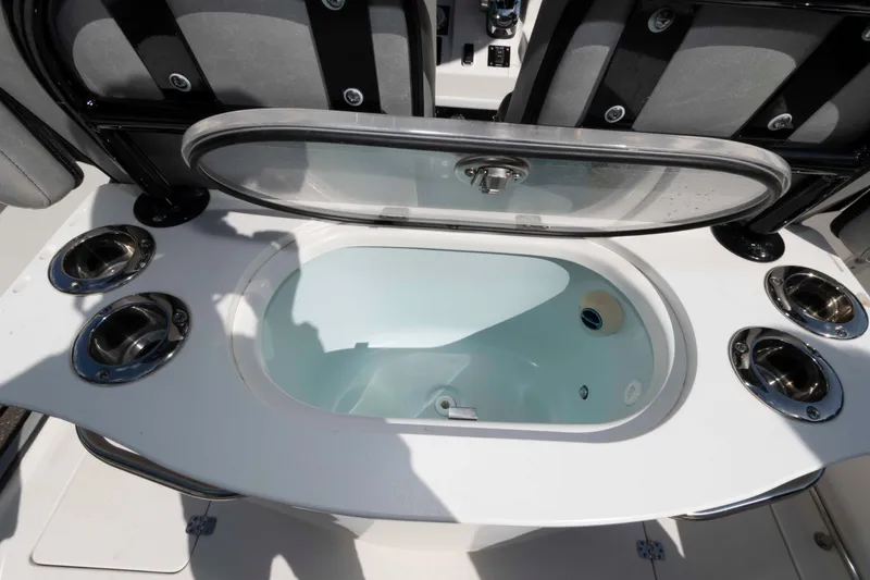 Slide: The Image of Livewell on 2020 Sea Pro 259 Center Console boat, featuring rod holders and seating. - 18