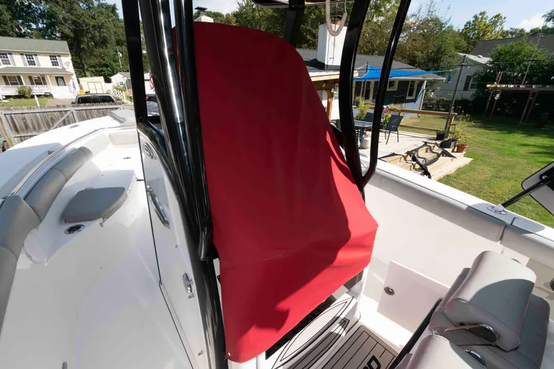 Slide: The Image of 2020 Sea Pro 259 Center Console boat with red cover, docked in a residential backyard. - 24