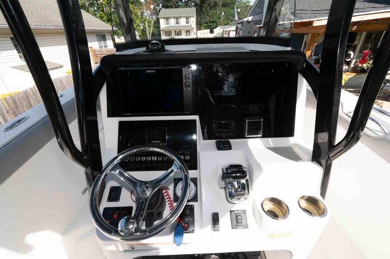 Slide: The Image of 2020 Sea Pro 259 Center Console boat dashboard with steering wheel and navigation controls. - 6