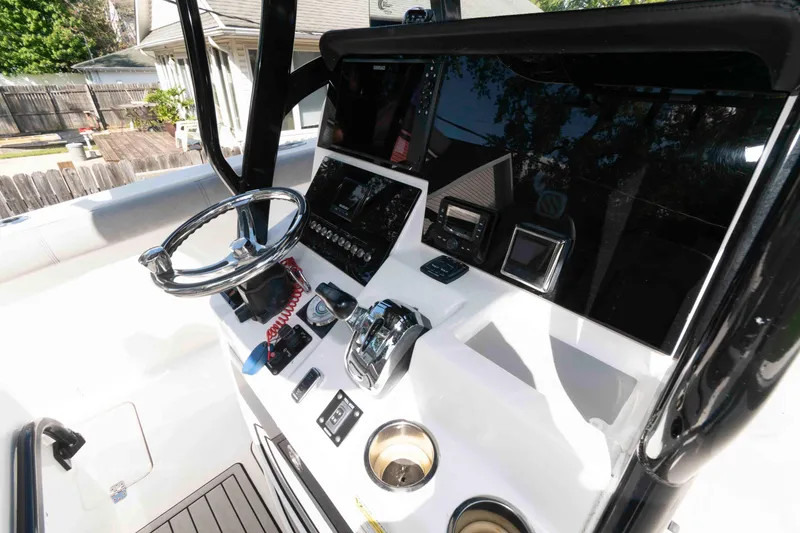 Slide: The Image of 2020 Sea Pro 259 Center Console boat dashboard with steering wheel and electronic controls. - 7