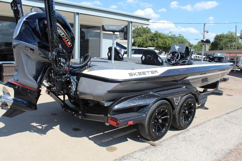 Slide: The Image of 2026 Skeeter FXR21 FLEX boat with powerful engine and sleek design on a trailer. - 2