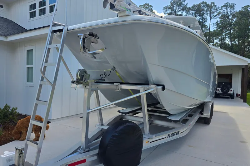 Slide: The Image of 2022 Invincible 33 Catamaran on trailer, parked in driveway near house. - 10