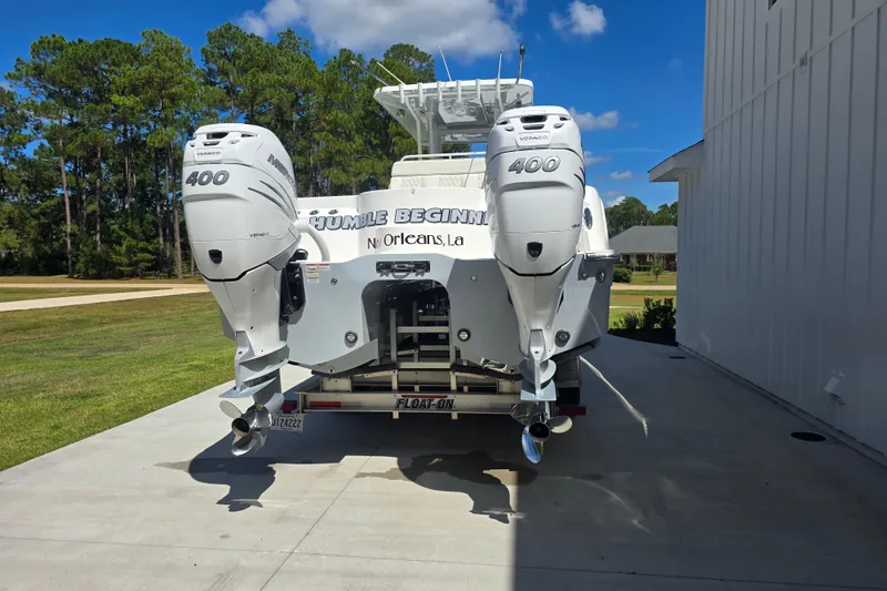 Slide: The Image of 2022 Invincible 33 Catamaran with twin 400 Verado engines, parked on a driveway. - 17