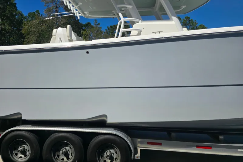 Slide: The Image of 2022 Invincible 33 Catamaran on trailer, side view under clear blue sky. - 3