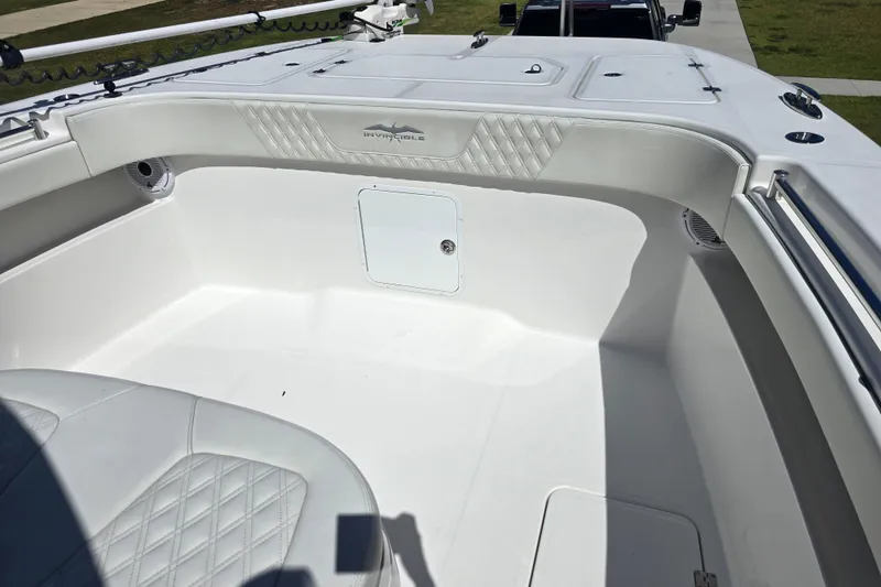 Slide: The Image of 2022 Invincible 33 Catamaran interior with white seating and storage compartments. - 37