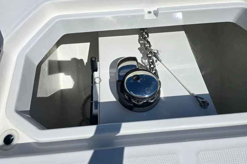 Slide: The Image of Anchor chain compartment of 2022 Invincible 33 Catamaran, featuring a polished windlass. - 39