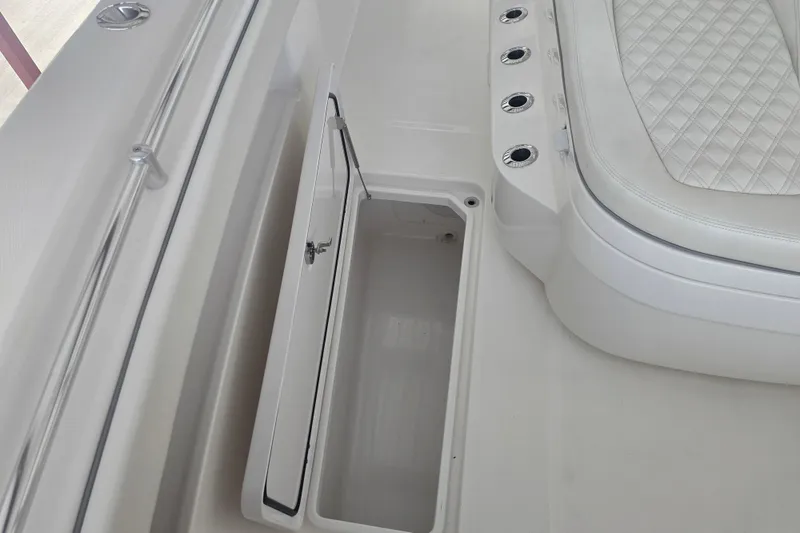 Slide: The Image of 2022 Invincible 33 Catamaran interior with open storage compartment and cushioned seating. - 46