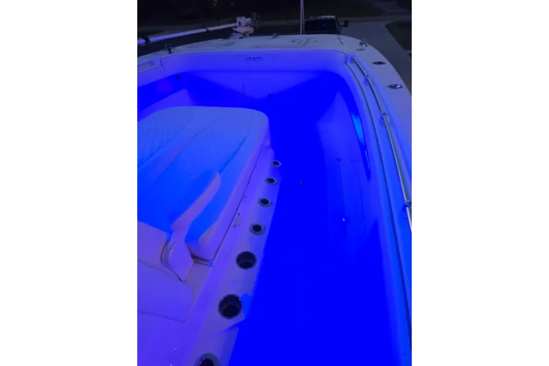 Slide: The Image of 2022 Invincible 33 Catamaran interior with blue LED lighting and cushioned seating. - 60