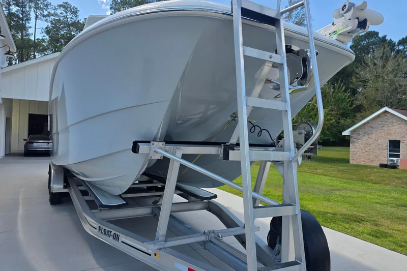 Slide: The Image of 2022 Invincible 33 Catamaran on trailer, parked in driveway near house. - 9