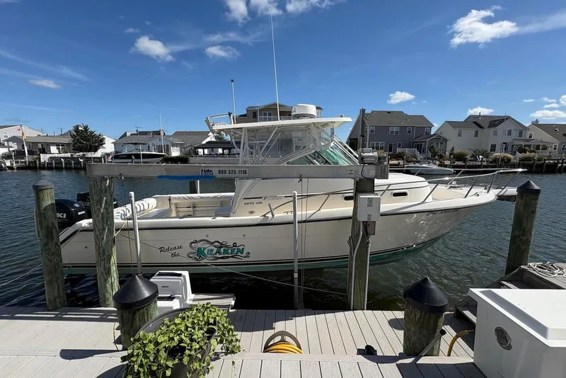 The Image of 2001 Pursuit 2870 Walkaround boat docked in a marina under a clear blue sky. - 0