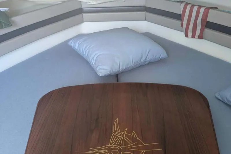 Slide: The Image of Interior cabin of 2001 Pursuit 2870 Walkaround with cushions and wooden table. - 13