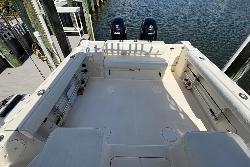 Slide: The Image of 2001 Pursuit 2870 Walkaround boat interior with dual Suzuki 200 engines, docked by the water. - 14