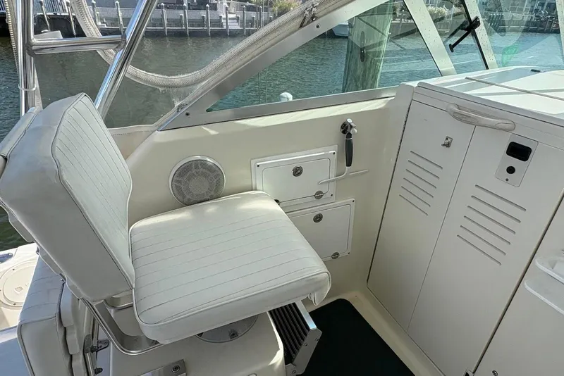 Slide: The Image of 2001 Pursuit 2870 Walkaround boat interior with white seating and storage compartments. - 23