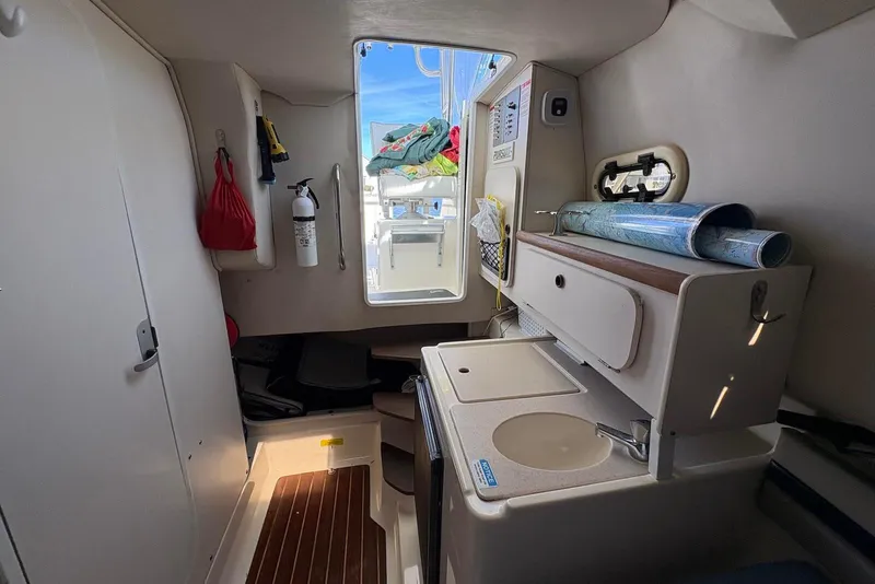 Slide: The Image of 2001 Pursuit 2870 Walkaround cabin interior with kitchenette and storage. - 27