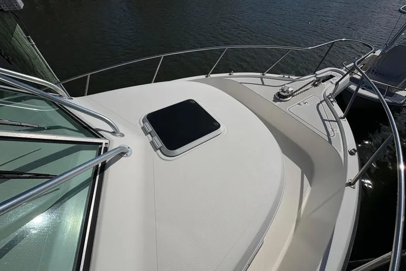 Slide: The Image of 2001 Pursuit 2870 Walkaround boat deck with railing and hatch, docked on water. - 32