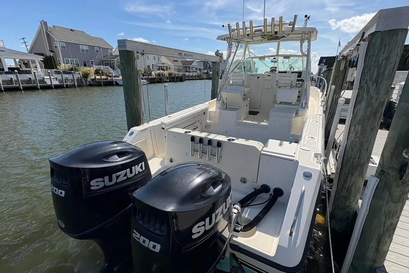 Slide: The Image of 2001 Pursuit 2870 Walkaround boat docked with twin Suzuki 200 engines. - 35