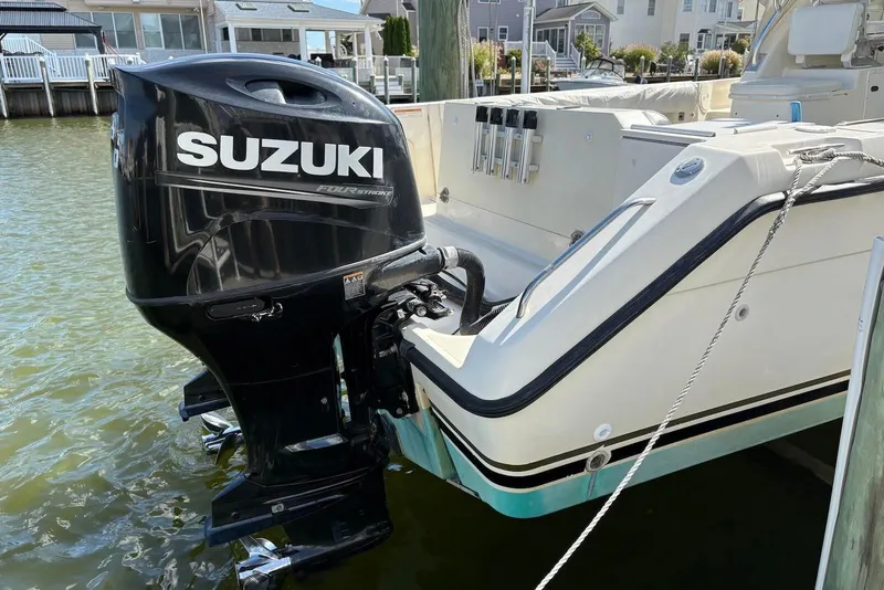 Slide: The Image of 2001 Pursuit 2870 Walkaround with Suzuki outboard motor docked in marina. - 37