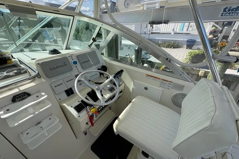 Slide: The Image of 2001 Pursuit 2870 Walkaround boat cockpit with Garmin navigation system and white seating. - 9