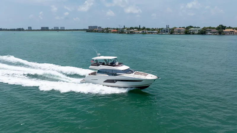 Slide: The Image of Aerial view of a 2019 Prestige 520 Flybridge yacht cruising on green water. - 40