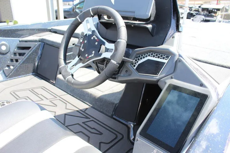 Slide: The Image of 2026 Skeeter FXR21 FLEX boat interior with steering wheel and digital display. - 15