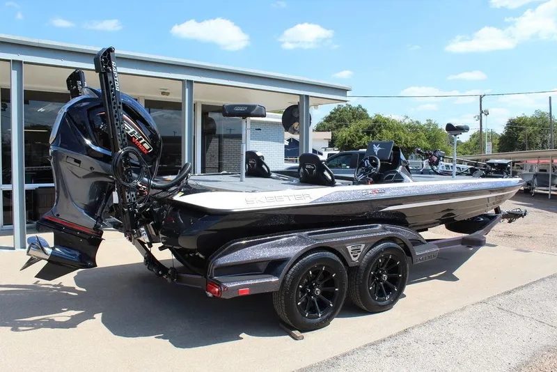Slide: The Image of 2026 Skeeter FXR21 FLEX boat with trailer, parked outdoors under a clear sky. - 3