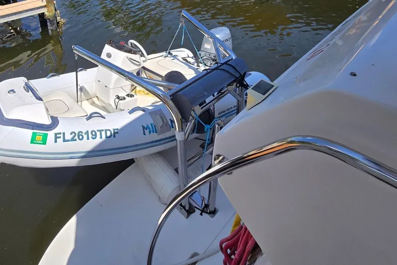 Slide: The Image of 2004 Sea Ray 480 Motor Yacht with attached dinghy on water. - 24