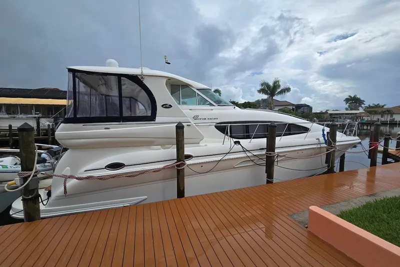 Slide: The Image of 2004 Sea Ray 480 Motor Yacht docked, showcasing sleek design and spacious cabin. - 29