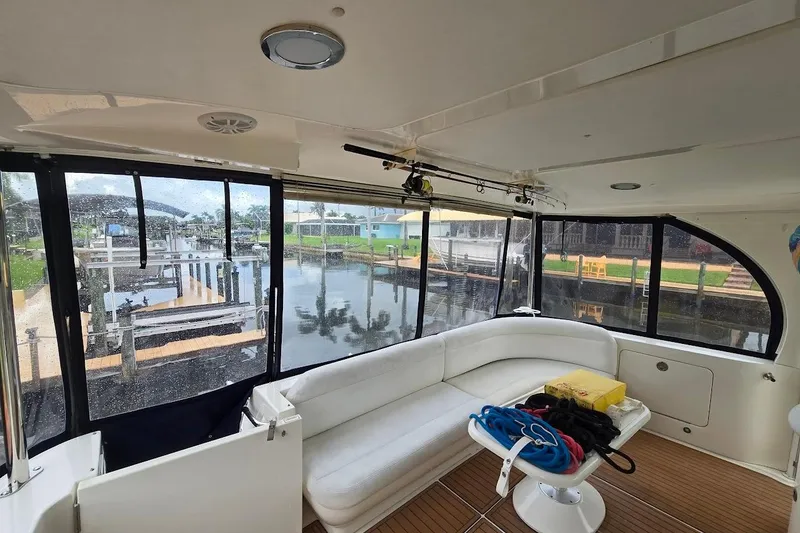 Slide: The Image of Interior of 2004 Sea Ray 480 Motor Yacht with white seating and marina view. - 30