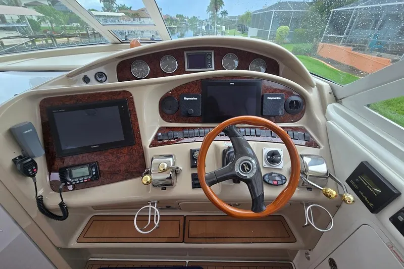 Slide: The Image of 2004 Sea Ray 480 Motor Yacht helm with wood steering wheel and navigation instruments. - 31