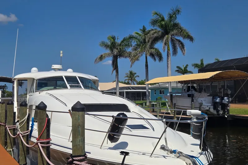 Slide: The Image of 2004 Sea Ray 480 Motor Yacht docked near palm trees under a clear blue sky. - 6