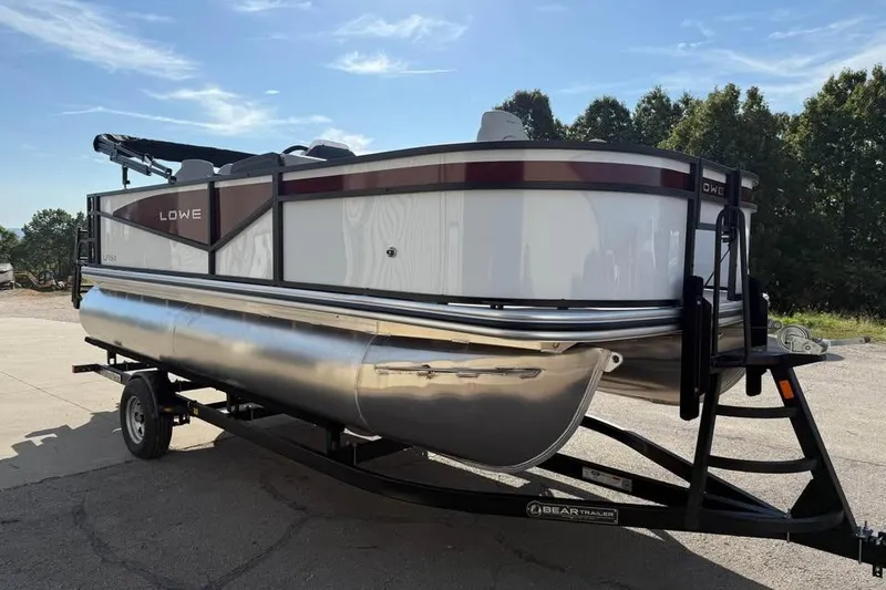 Slide: The Image of 2026 Lowe LF 194 pontoon boat on trailer under clear blue sky. - 3