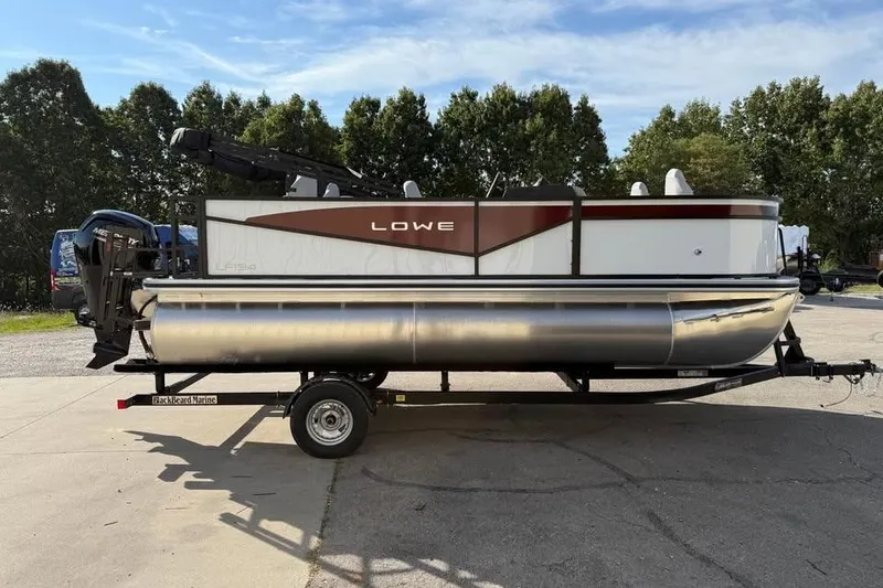 Slide: The Image of 2026 Lowe LF 194 pontoon boat on trailer, parked outdoors. - 4