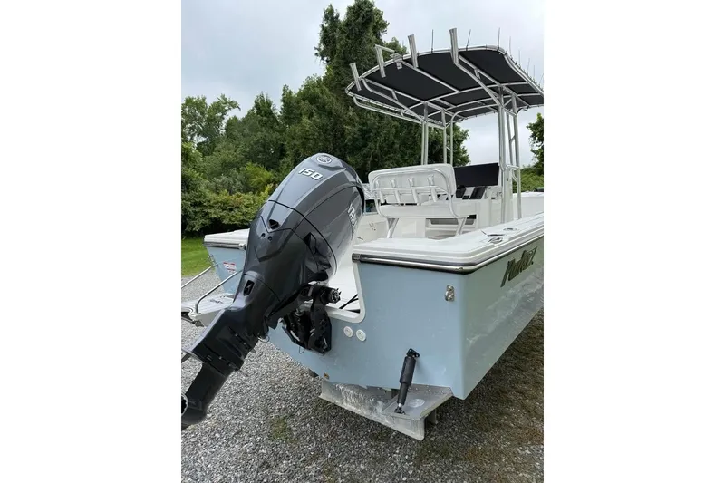 Slide: The Image of 2026 Parker 210 Coastal boat, white interior, parked outdoors near greenery and a tractor. - 3