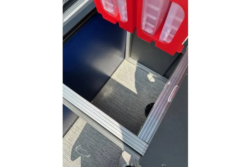 Slide: The Image of Interior storage compartment of 2026 Bennington 23 SF Family boat with red tackle boxes. - 28