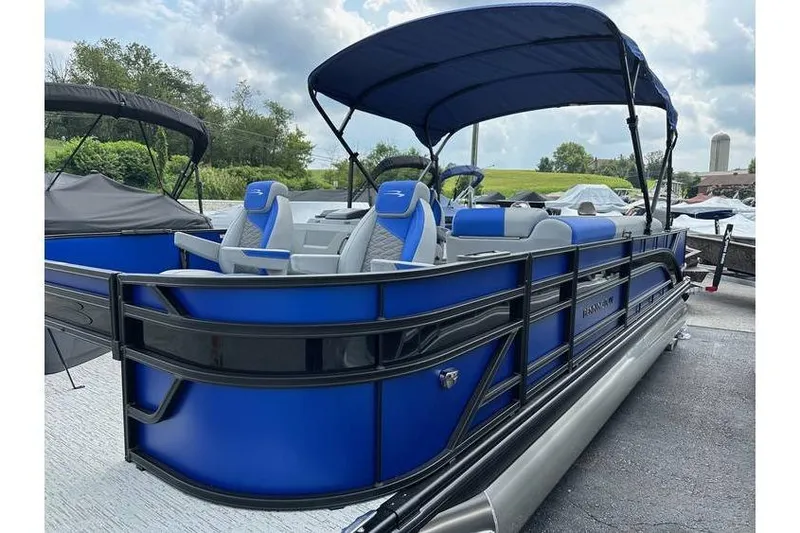 Slide: The Image of 2026 Bennington 23 SF Family pontoon boat, blue with canopy, parked outdoors. - 4