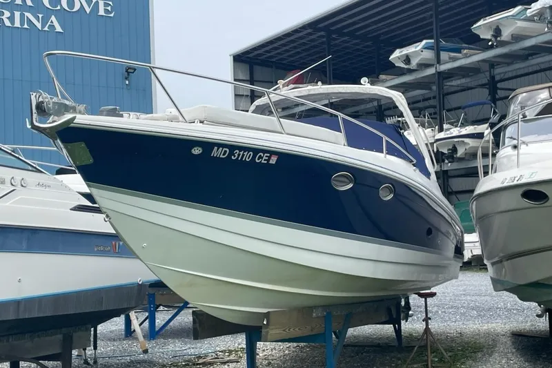 The Image of 2004 Formula 330 Sun Sport boat docked at a marina, blue and white exterior. - 0