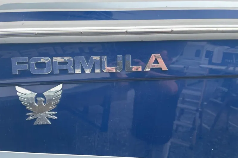 Slide: The Image of 2004 Formula 330 Sun Sport boat emblem on blue surface. - 3