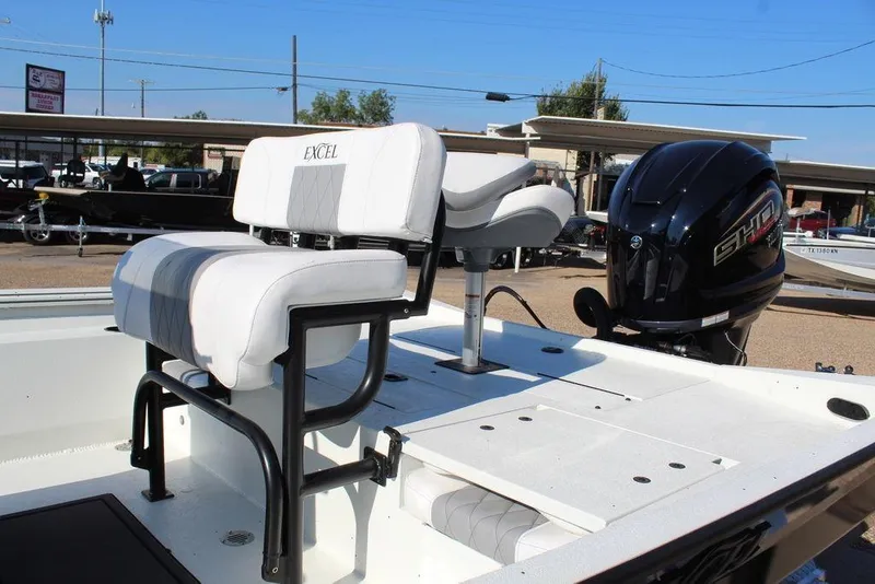 Slide: The Image of 2026 Excel Bay Pro Elite 220 boat with cushioned seating and powerful outboard motor. - 12