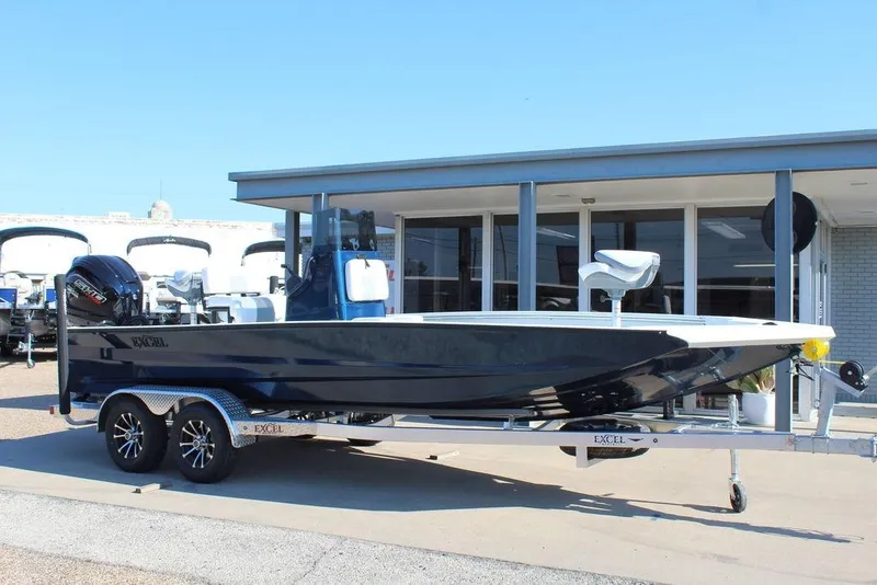 Slide: The Image of 2026 Excel Bay Pro Elite 220 boat on trailer, parked outside a building. - 5