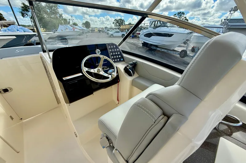 Slide: The Image of 2026 Scout 255 Dorado boat interior with steering wheel and comfortable seating. - 17