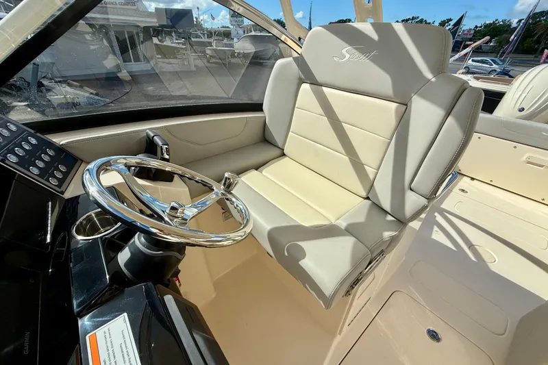 Slide: The Image of 2026 Scout 255 Dorado boat interior with steering wheel and beige seating. - 18